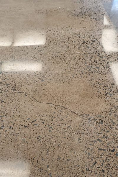 Mechanically polished concrete floor in a Halifax residential basement, featuring a high-gloss, mirror-like finish that reflects ambient light.