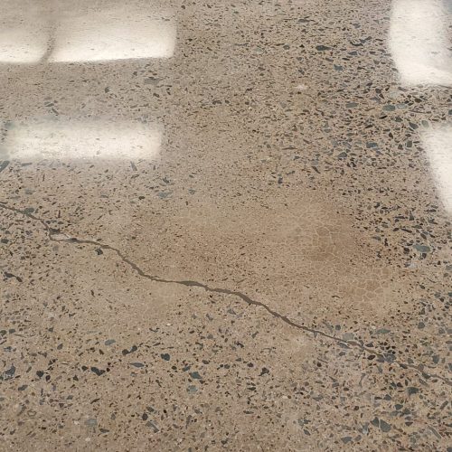 Mechanically polished concrete floor in a Halifax residential basement, featuring a high-gloss, mirror-like finish that reflects ambient light.