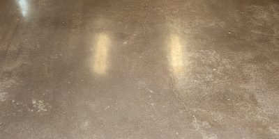 residential garage concrete floor being mechanically ground and sealed to create a dust-proof, stain-resistant, and low-maintenance surface.