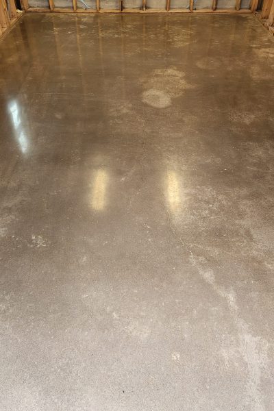 residential garage concrete floor being mechanically ground and sealed to create a dust-proof, stain-resistant, and low-maintenance surface.