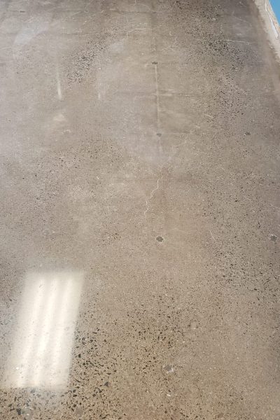 Large-scale commercial warehouse floor with a satin-finish polished concrete treatment, providing a durable and slip-resistant surface.