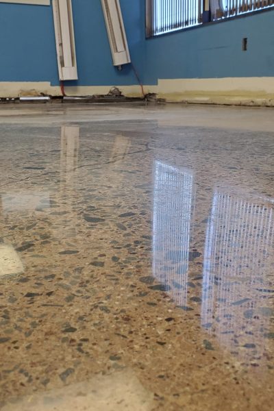Close-up of a mechanically honed concrete floor showing industrial diamond grinding results and a smooth, dust-proof surface.